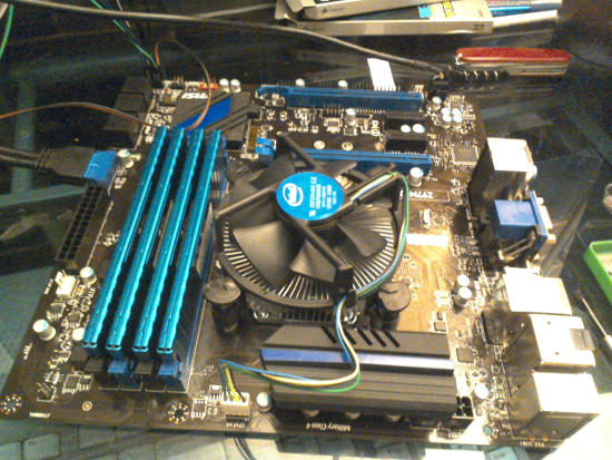 Four RAM sticks being placed on the motherboard next to the CPU fan.